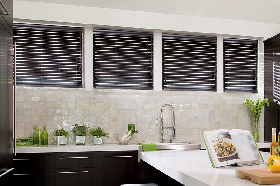 Choose custom Polywood faux wood blinds for your kitchen in Southern California. Special shaped faux wood blinds in several windows above a sink.