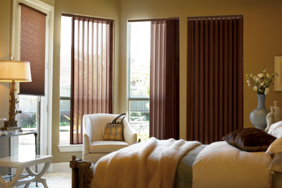 Choose durable and high-quality fabric or vinyl vertical blinds in Southern California. Maroon fabric vertical blinds inside a bedroom