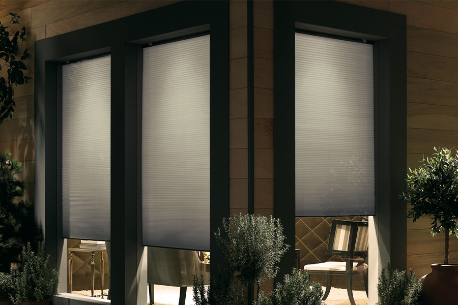 Cellular shades are modern and stylish window treatments for your home in Southern California. Dark gray cellular shades displayed from the exterior of a home.